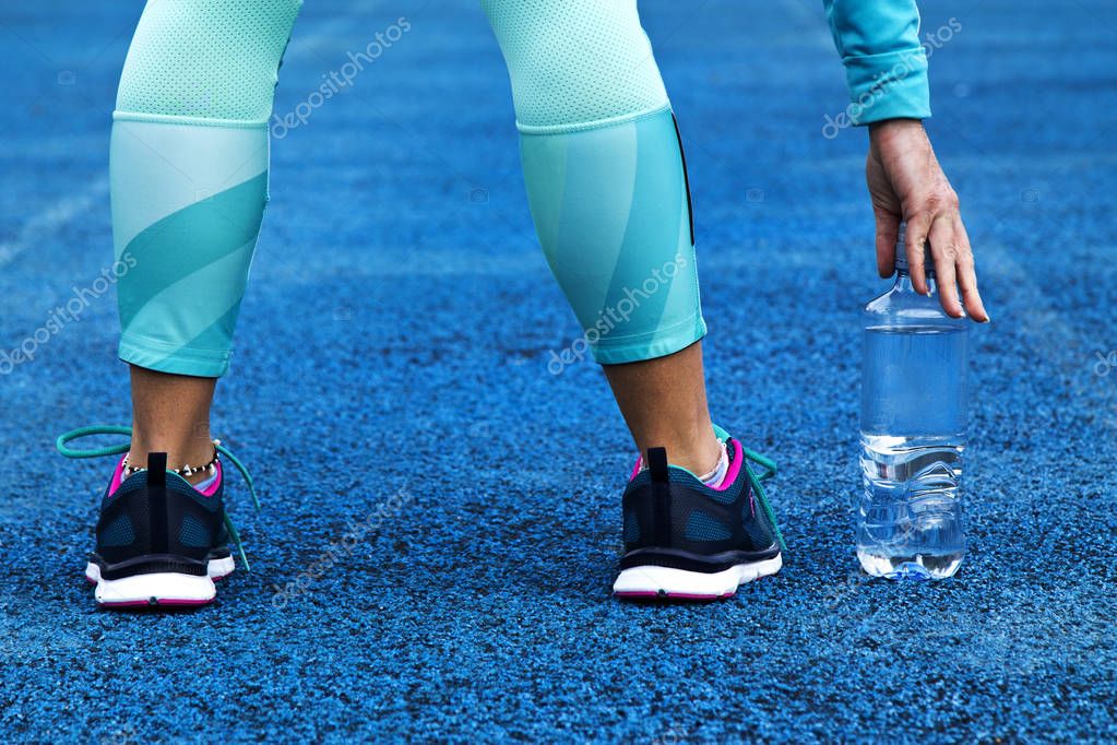 Female legs and water bottle on running track — Stock Photo © tetxu