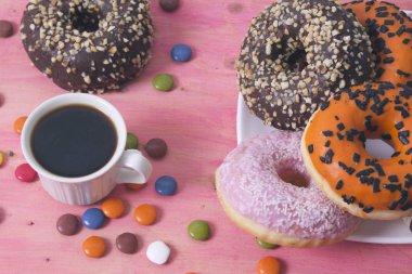 Çörek ve smarties pembe bir arka plan üzerinde kahve