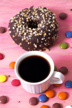 Çörek ve smarties pembe bir arka plan üzerinde kahve