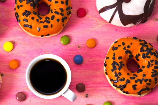 Чашка кави з пончиками та посмішками на рожевому фоні — стокове фото