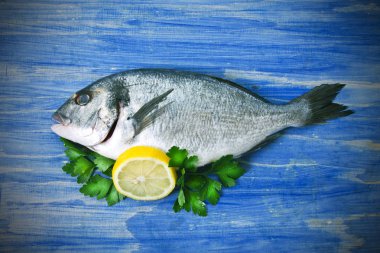 Balık, Eşkine maydanoz ve limon mavi ahşap zemin ile