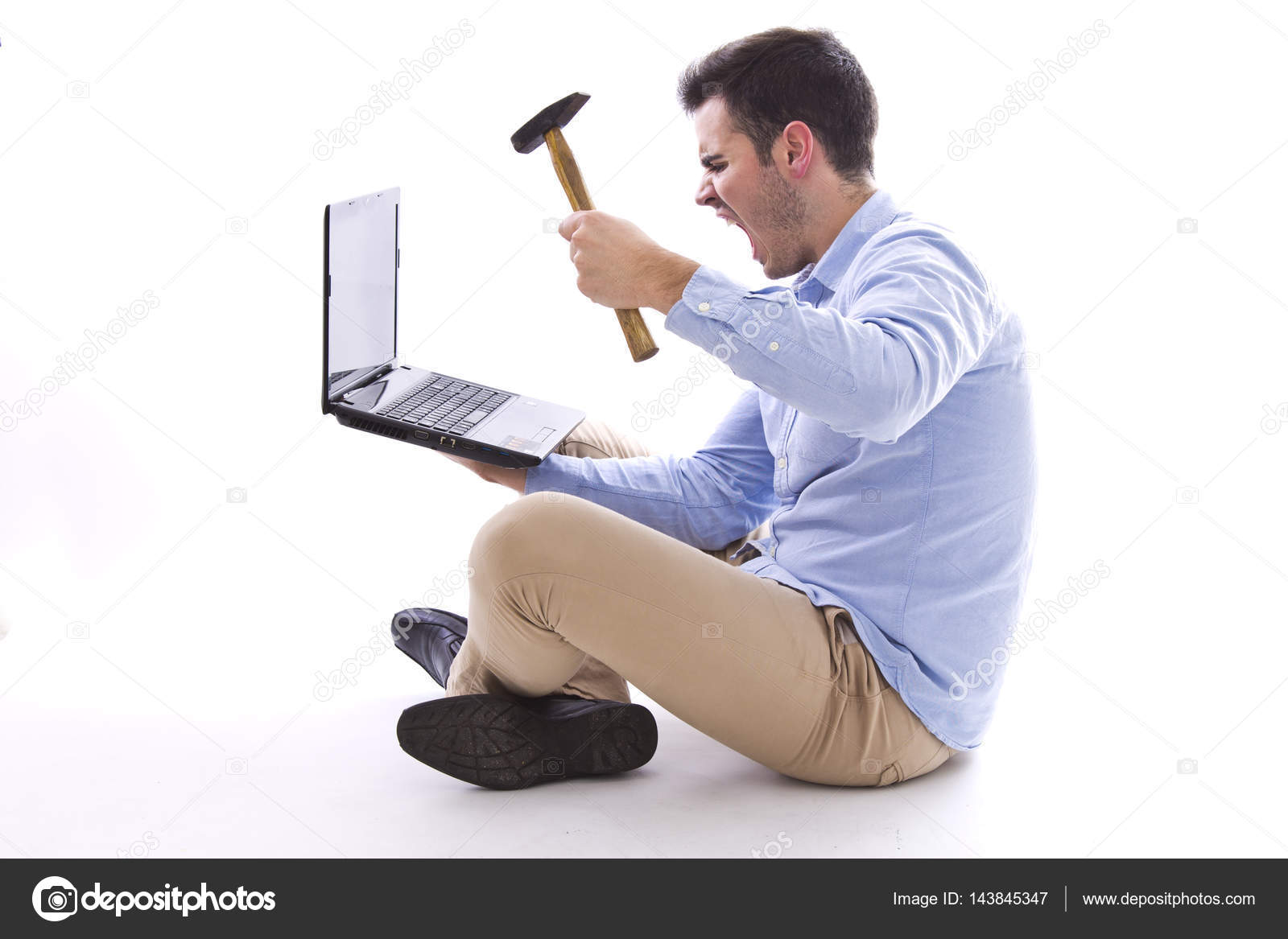 Man sitting on the floor hitting the computer with hammer — Stock Photo