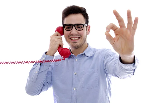 Hombre joven con el teléfono rojo haciendo símbolo ok — Foto de Stock