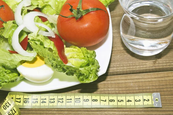 Salade met een glas water en meetlint — Stockfoto