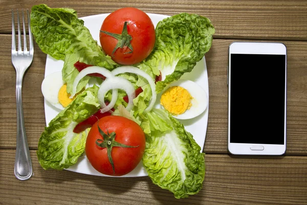 Salada saborosa e telefone celular — Fotografia de Stock