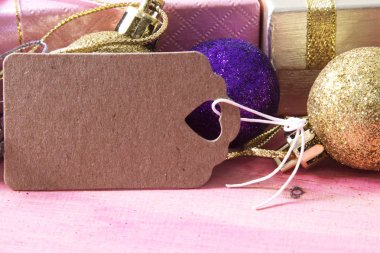 Noel kartı hediye kutusu ve etiket pembe ahşap üzerinde