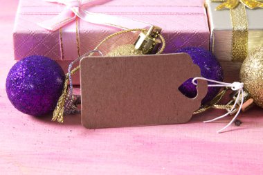 Noel kartı hediye kutusu ve etiket pembe ahşap üzerinde