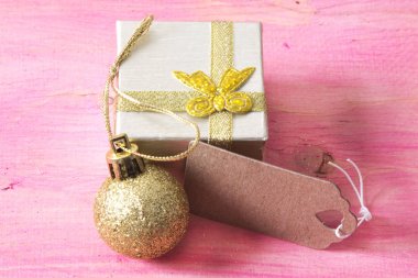 Noel kartı hediye kutusu ve etiket pembe ahşap üzerinde