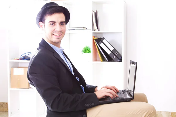 Młody człowiek za pomocą laptopa, w biurze — Zdjęcie stockowe