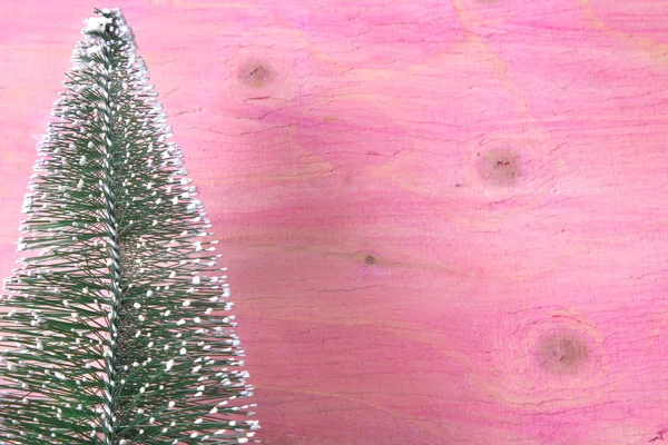 クリスマス ラベルとピンクの木製の背景上にクリスマス ツリー — ストック写真
