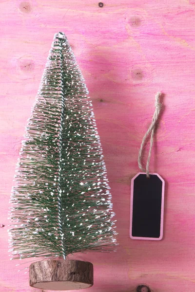 Arbre de Noël sur fond de bois rose avec étiquette — Photo