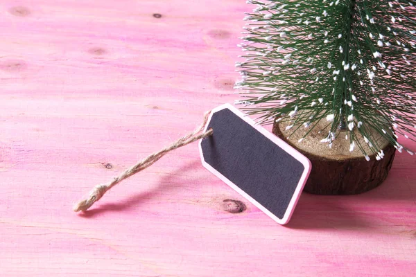 圣诞树上粉色木制背景与标签 — 图库照片