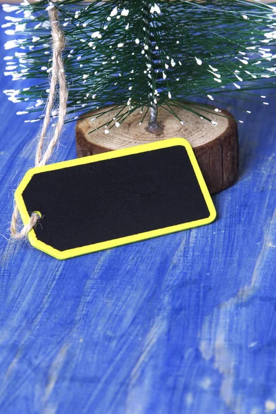 Різдвяна ялинка на синьому дерев'яному фоні з міткою — стокове фото