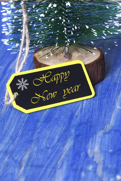 Árvore de Natal em fundo de madeira azul com etiqueta — Fotografia de Stock