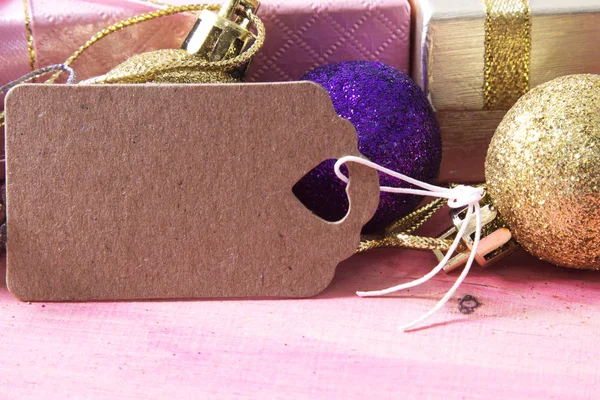 Noel kartı hediye kutusu ve etiket pembe ahşap üzerinde