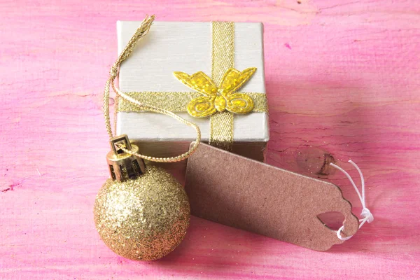 Cartão de Natal com caixa de presente e etiqueta em madeira rosa — Fotografia de Stock