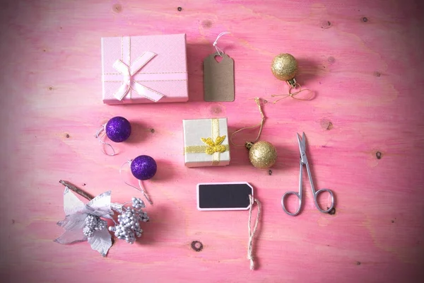 Tarjeta de Navidad con tijeras, regalos y decoraciones Navidad sobre fondo rosa —  Fotos de Stock