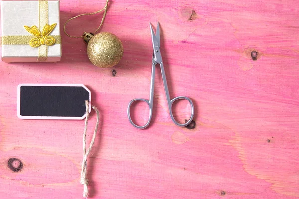 Carta Natale con forbici, regalo e decorazioni Natale su sfondo rosa — Foto Stock