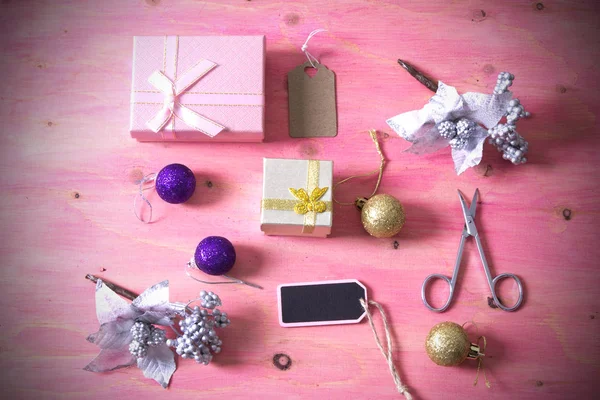 Tarjeta de Navidad con tijeras, regalos y decoraciones Navidad sobre fondo rosa — Foto de Stock