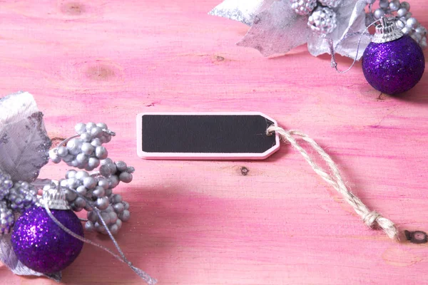 Tarjeta de Navidad con etiqueta, caja de regalo y bolas de Navidad sobre fondo rosa —  Fotos de Stock
