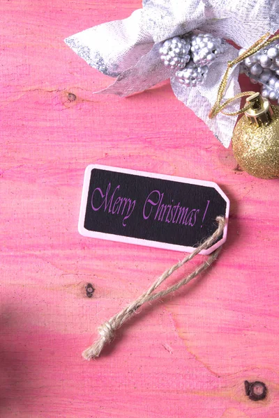 Růžové vánoční pozadí s kartou a vánoční ozdoby — Stock fotografie