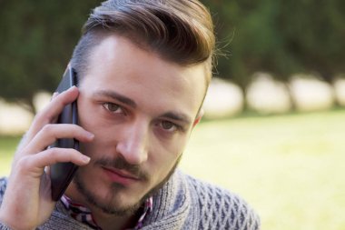 Genç adam hipster cep telefonu üzerinde konuşurken