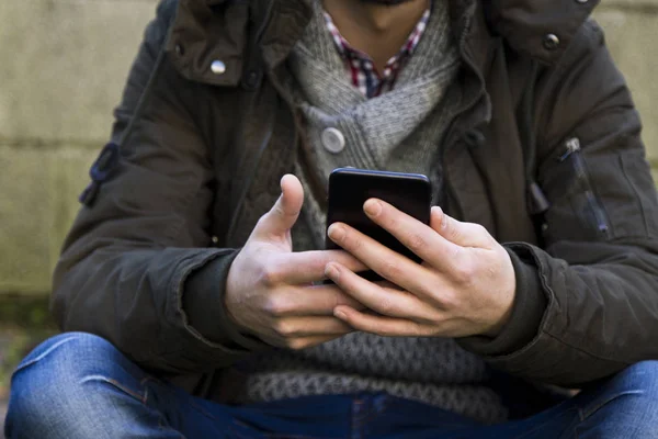 Hareket eden telefon ile oturan genç adam — Stok fotoğraf