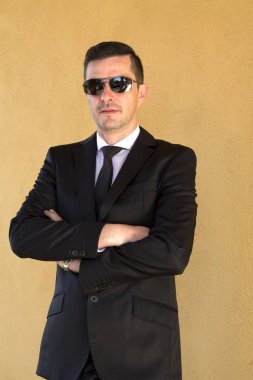 Sarı duvar arka plan ile takım elbiseli olgun adam