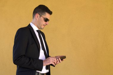 Cep telefonu kullaranarak takım elbiseli genç adam