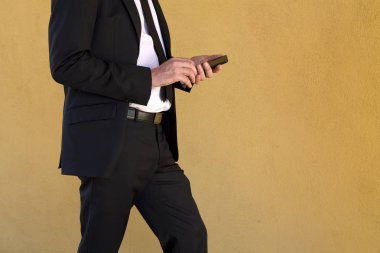 Cep telefonu kullaranarak takım elbiseli genç adam