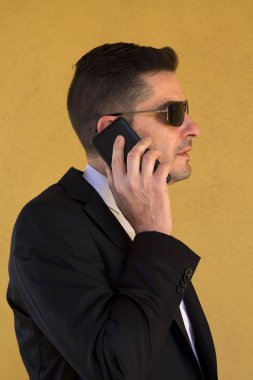 Cep telefonu ile konuşurken takım elbiseli genç adam