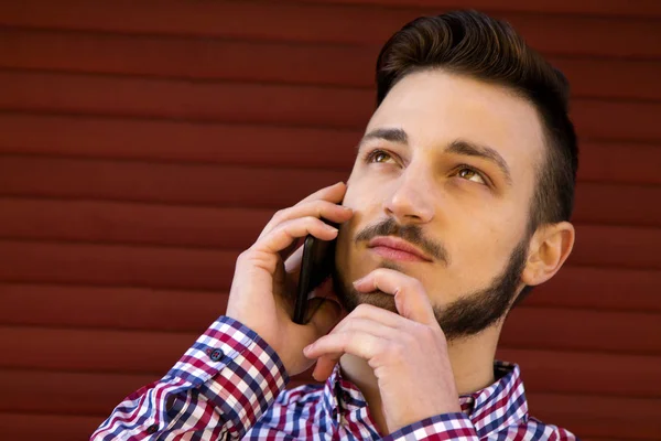 Hipster man talar på mobiltelefonen och tänkande — Stockfoto