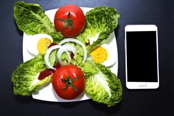 Salada de tomate e telefone celular — Fotografia de Stock
