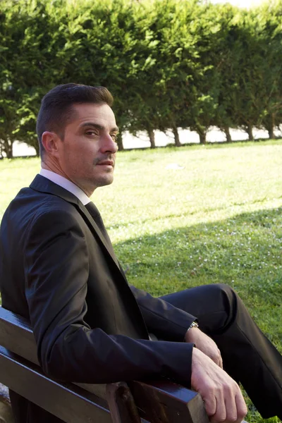 Man in suit sitting in the park