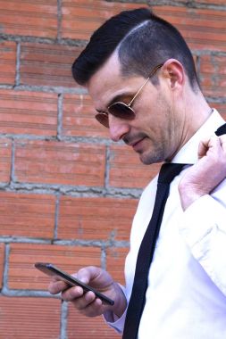 Cep telefonu kullaranarak takım elbiseli genç adam