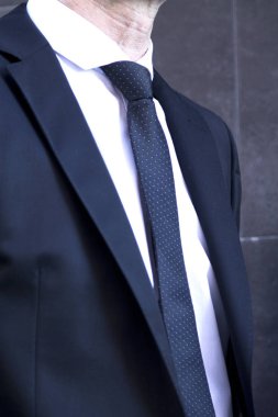 Düğmelerin üzerinde elleriyle takım elbiseli adam