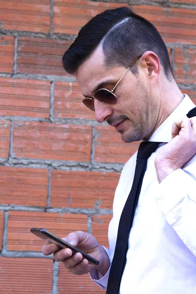 Cep telefonu kullaranarak takım elbiseli genç adam