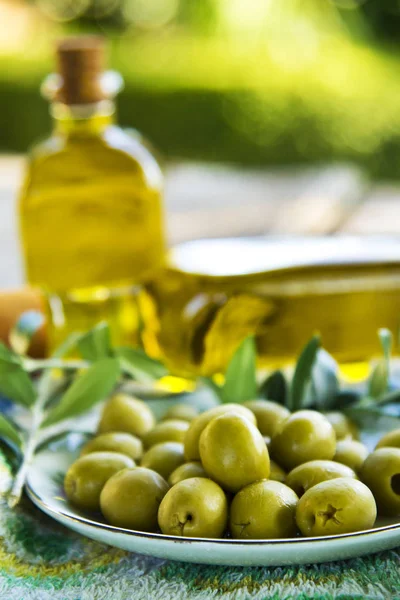 Plato de oliva y botellas de aceite de oliva — Foto de Stock