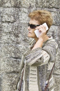 Cep telefonu kullanan yaşlı bir kadın.