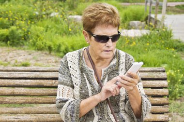 Cep telefonu kullanan yaşlı bir kadın.