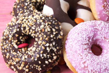 ssortment ile şeker pembe ahşap arka plan üzerinde renkli Donuts