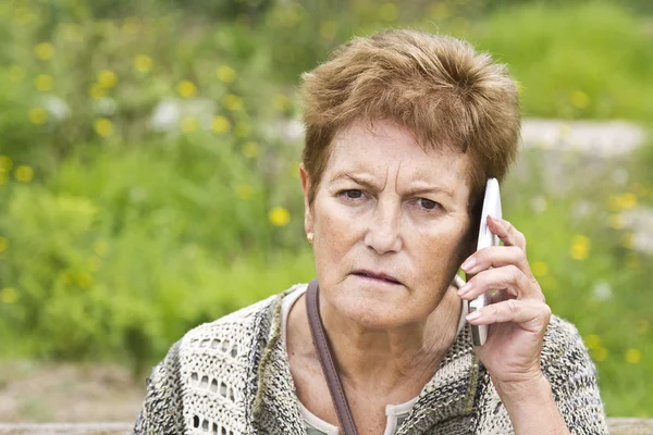 Cep telefonu kullanan yaşlı bir kadın.