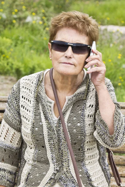 Cep telefonu kullanan yaşlı bir kadın.