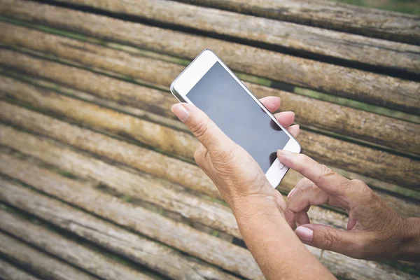 Mãos de mulher sênior com celular — Fotografia de Stock