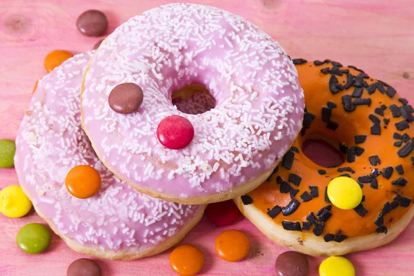 Sortimento de donuts coloridos com caramelos — Fotografia de Stock