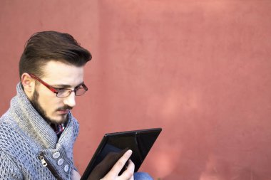 tablet kullanarak parkta oturan genç adam