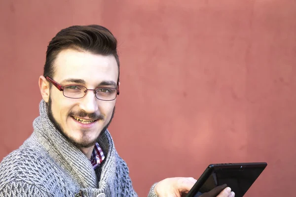 Giovane seduto nel parco con il tablet — Foto Stock