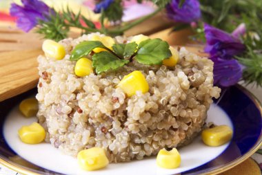 Quinoa salata üzerine beyaz izole tabakta Mısır ve yeşil bezelye ile