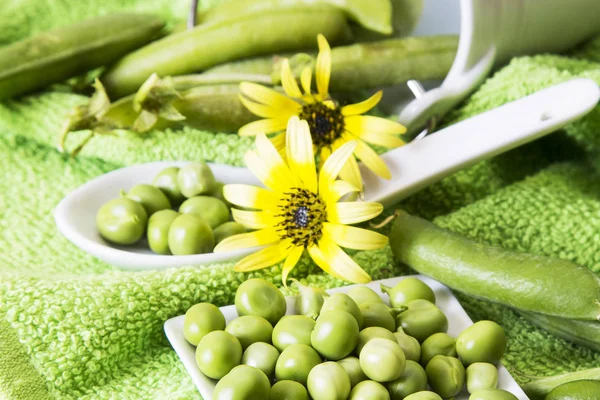 Cuchara de guisantes verdes en mantel colorido —  Fotos de Stock