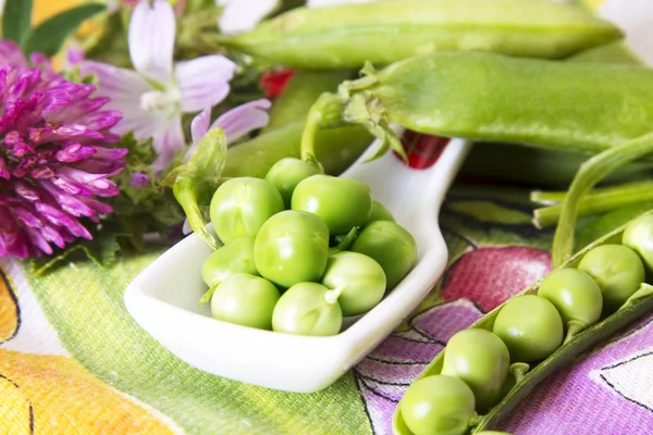 Cuchara de guisantes verdes en mantel colorido —  Fotos de Stock